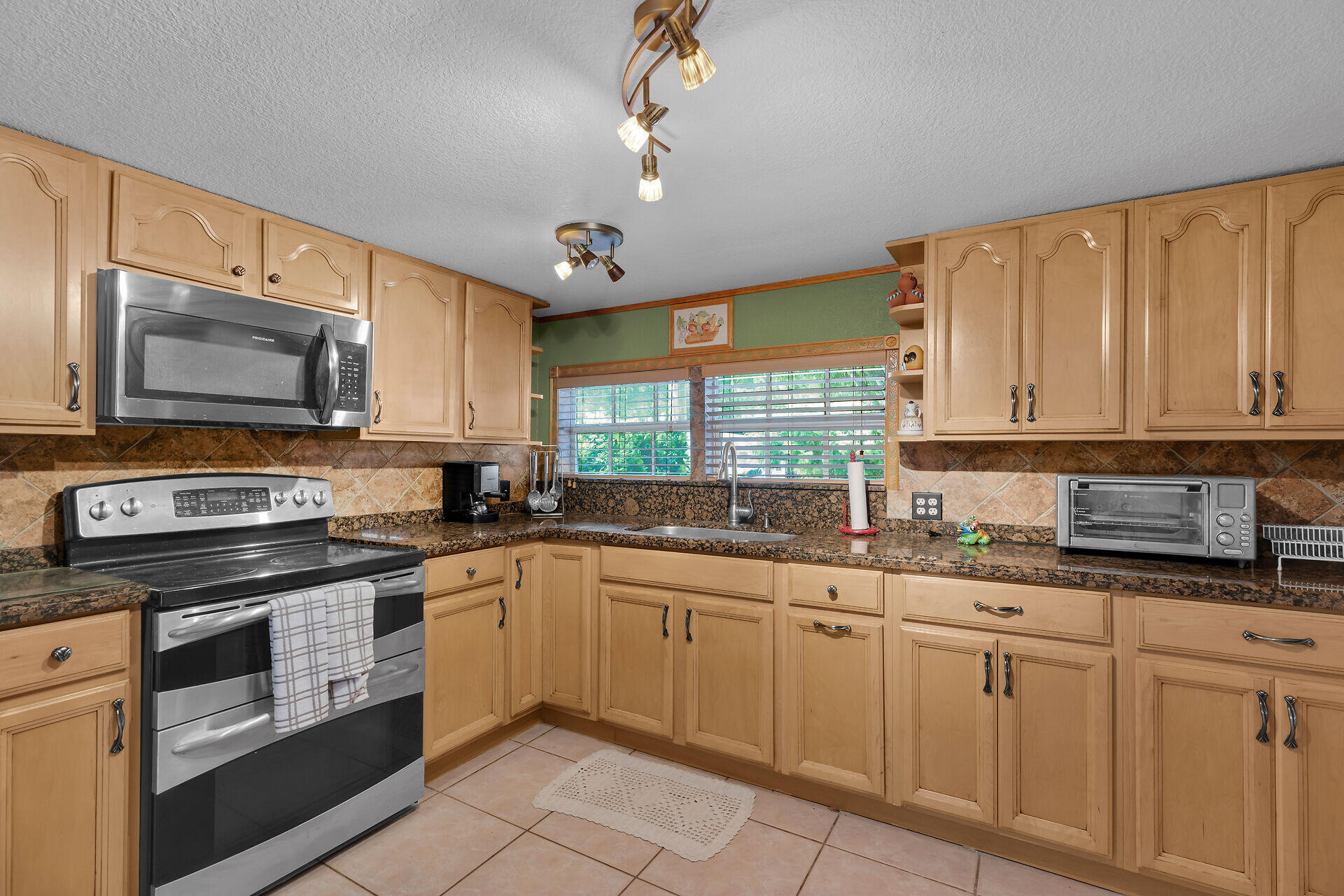 72 1st Court Key Largo, FL 33037 - Photo 8 of 30 a kitchen with granite countertop white cabinets stainless steel appliances a sink and a window