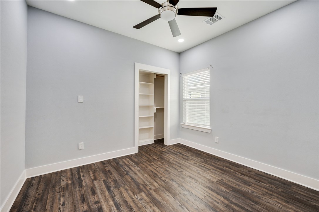 507 Walnut Street Bryan, TX 77803 - Photo 13 of 23 an empty room with wooden floor chandelier fan and windows