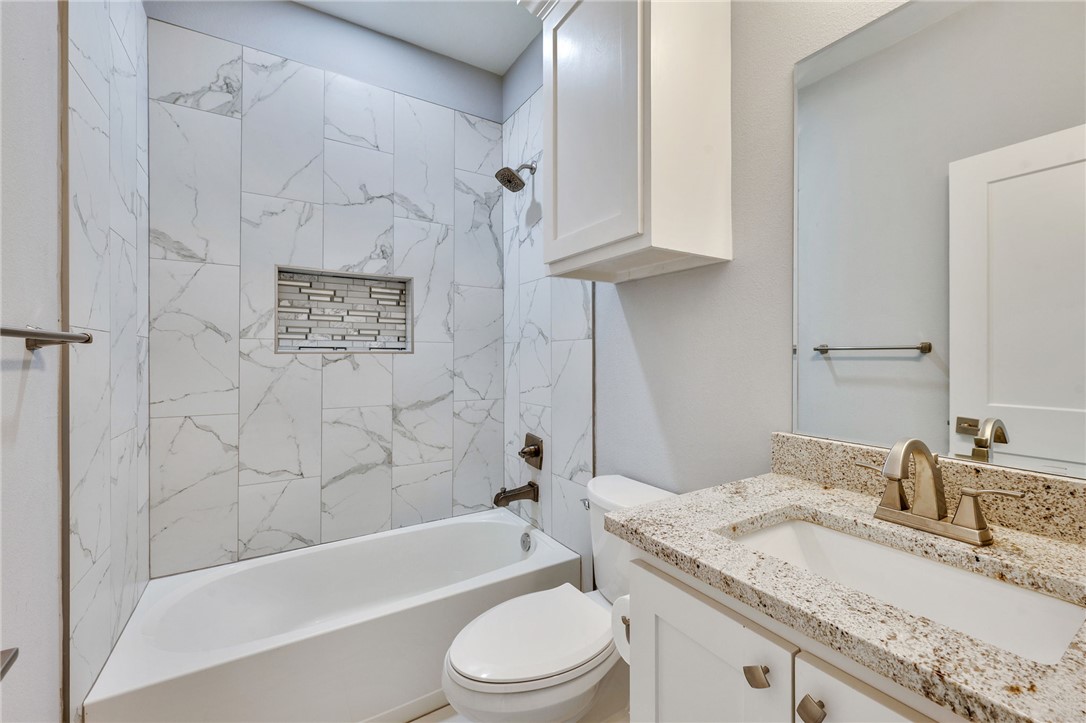 507 Walnut Street Bryan, TX 77803 - Photo 14 of 23 a bathroom with a granite countertop sink toilet and shower