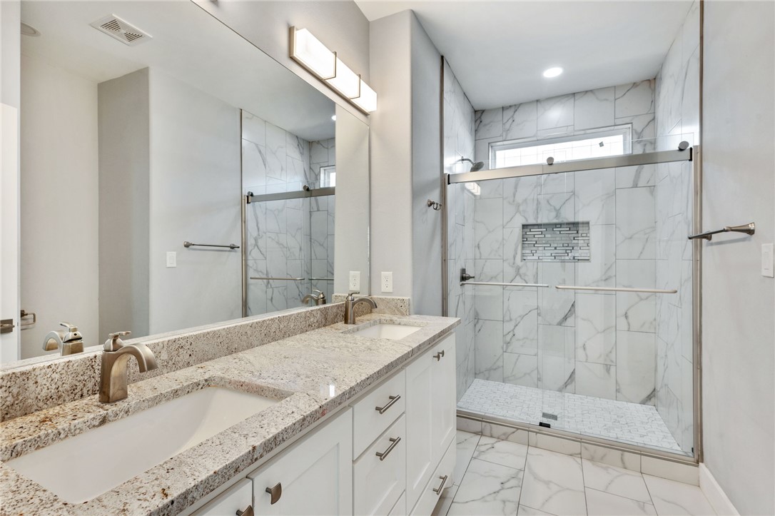 507 Walnut Street Bryan, TX 77803 - Photo 18 of 23 a bathroom with a granite countertop sink mirror and shower