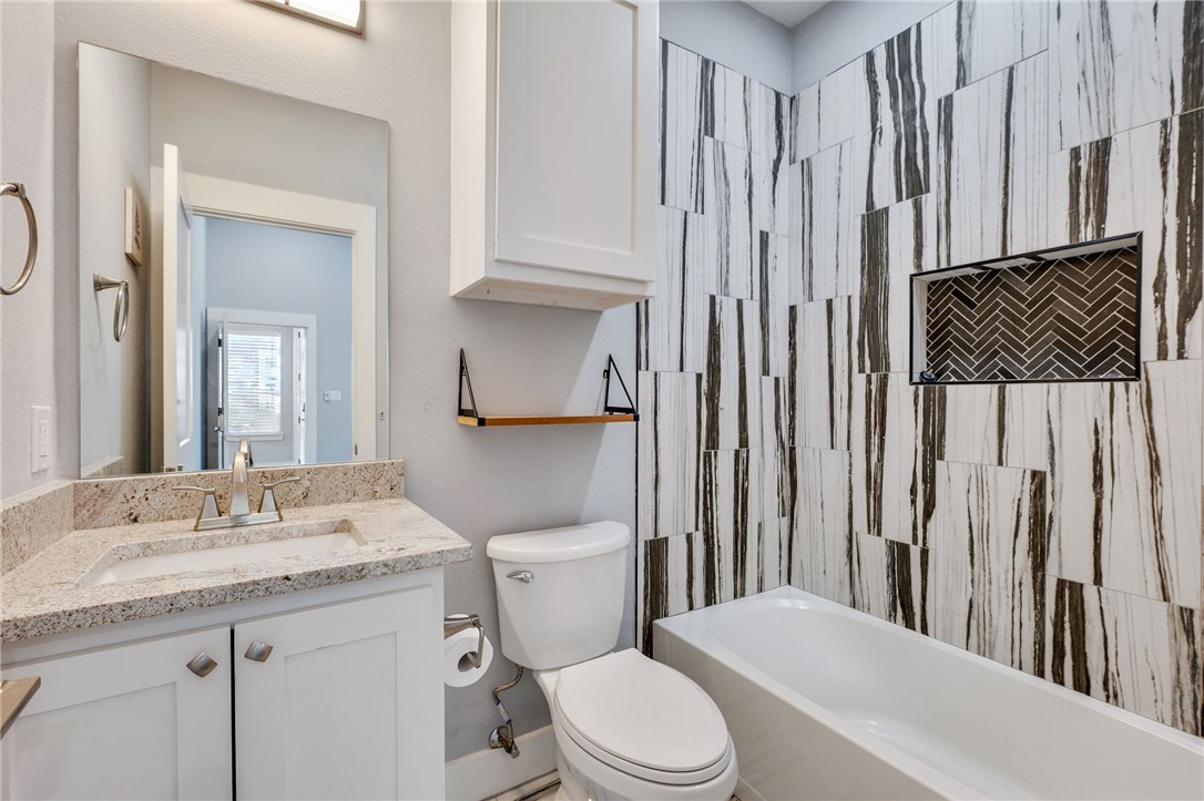 507 Walnut Street Bryan, TX 77803 - Photo 20 of 23 a bathroom with a granite countertop toilet sink and a mirror