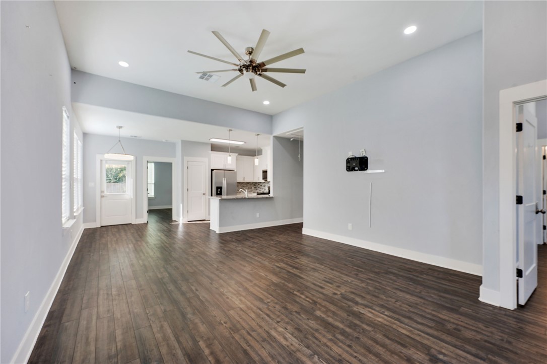 507 Walnut Street Bryan, TX 77803 - Photo 6 of 23 a view of a kitchen with wooden floor and a ceiling fan