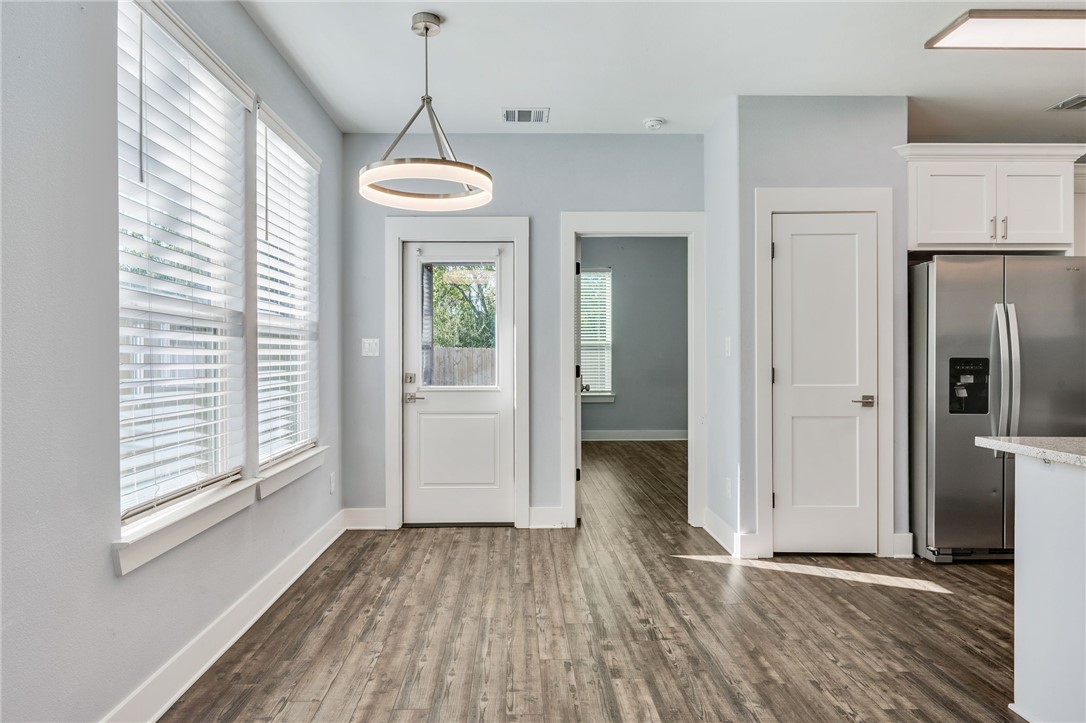 507 Walnut Street Bryan, TX 77803 - Photo 10 of 23 a view of a room with wooden floor a ceiling fan and windows