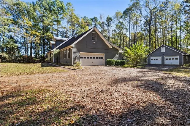 a view of a house with a yard and large tree