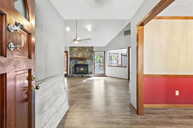 a view of an empty room with window and wooden floor