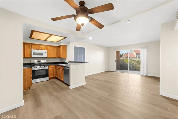 a kitchen with stainless steel appliances kitchen island wooden floors granite counter tops and a window