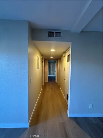 a view of a hallway with wooden floor