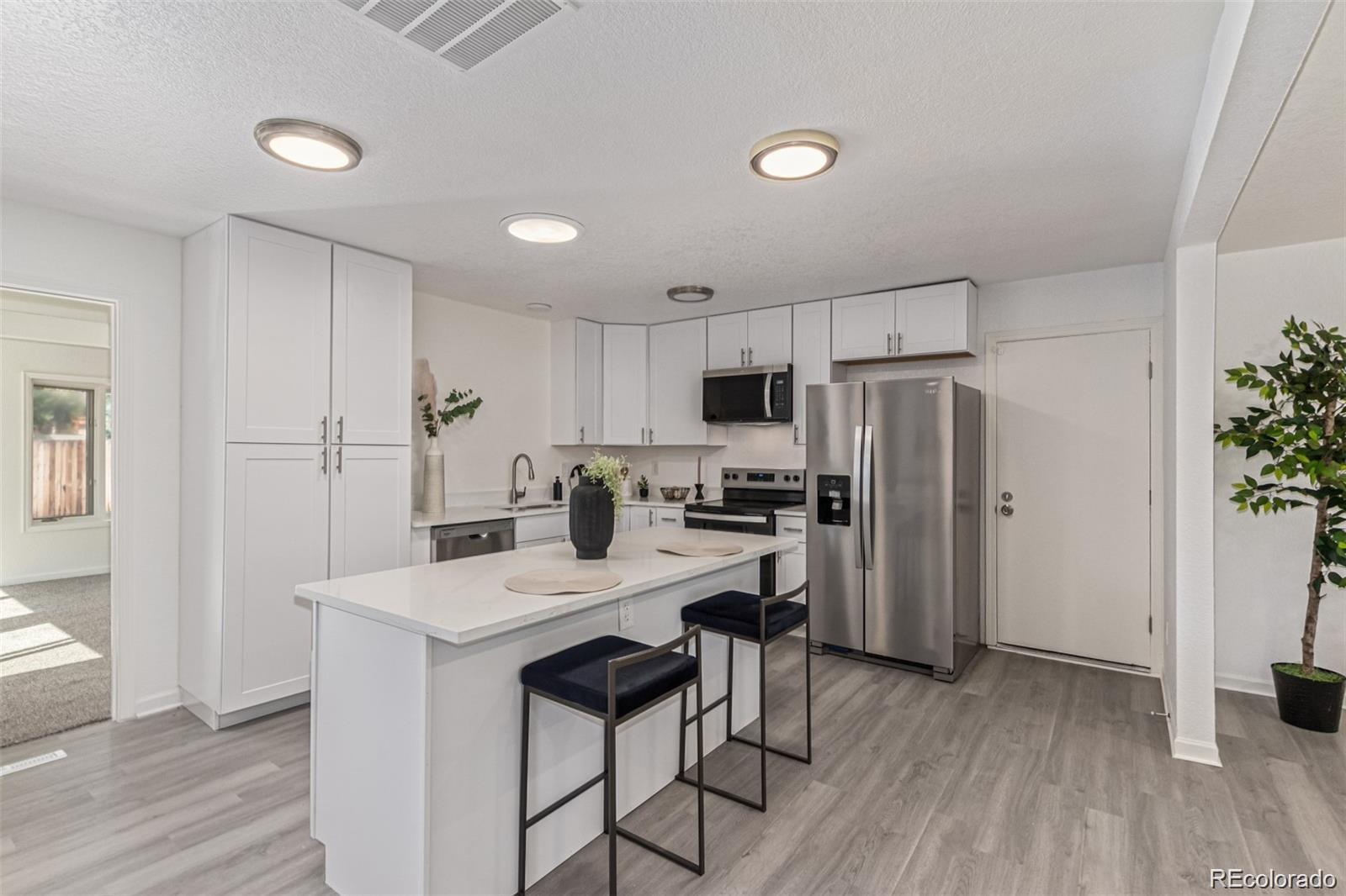 9495 Webster Way Broomfield, CO 80021 - Photo 12 of 32 a kitchen with refrigerator cabinets and wooden floor