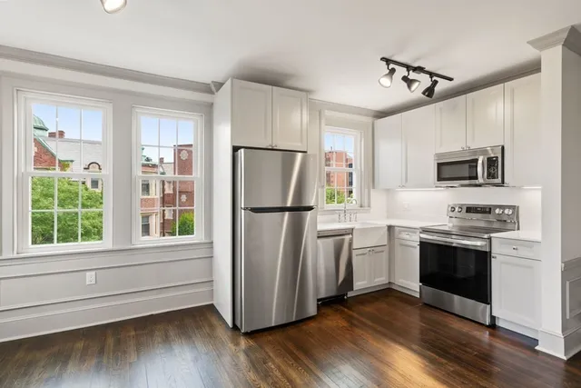 a kitchen with stainless steel appliances a refrigerator sink and microwave