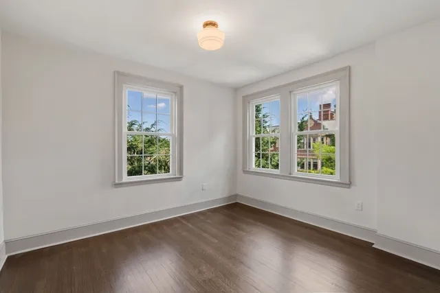an empty room with wooden floor and a window