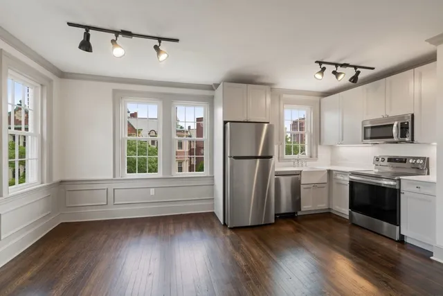 a kitchen with refrigerator cabinets and wooden floor