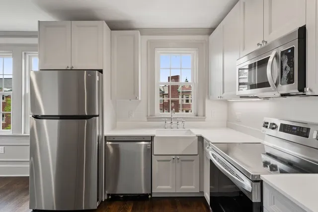 a kitchen with white cabinets and stainless steel appliances