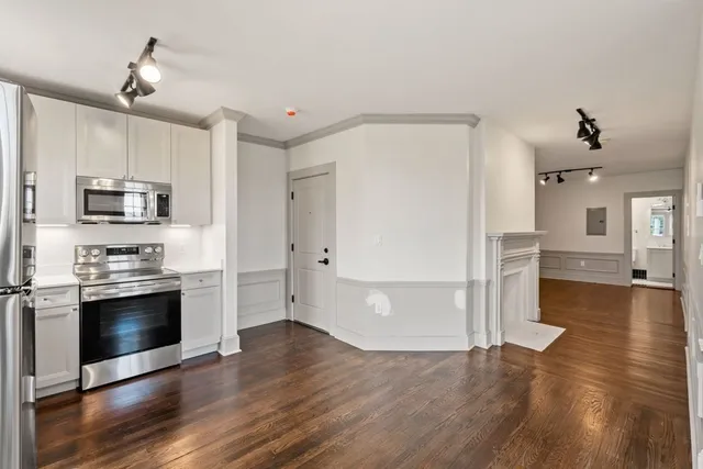 a view of a kitchen with wooden floor and electronic appliances