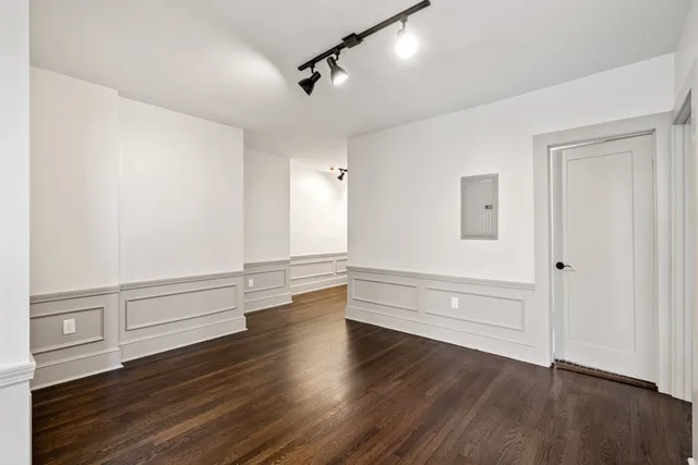 an empty room with wooden floor and window