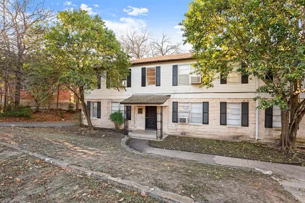 a front view of a house with a yard and trees