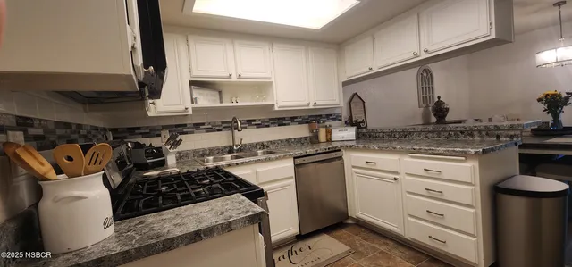a kitchen with white cabinets and appliances