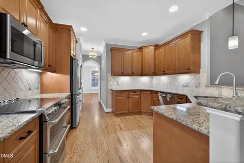 a kitchen with stainless steel appliances granite countertop a sink stove and refrigerator