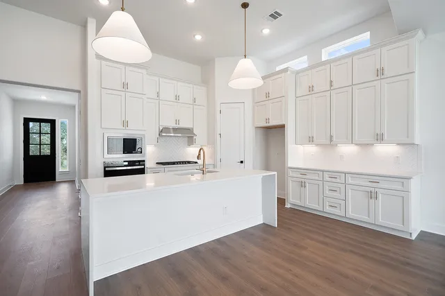 a kitchen with a sink cabinets and wooden floor