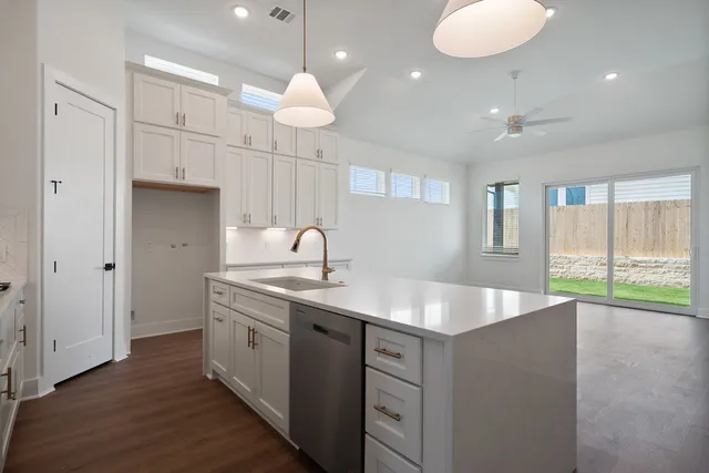 a view of a sink and dishwasher with wooden floor