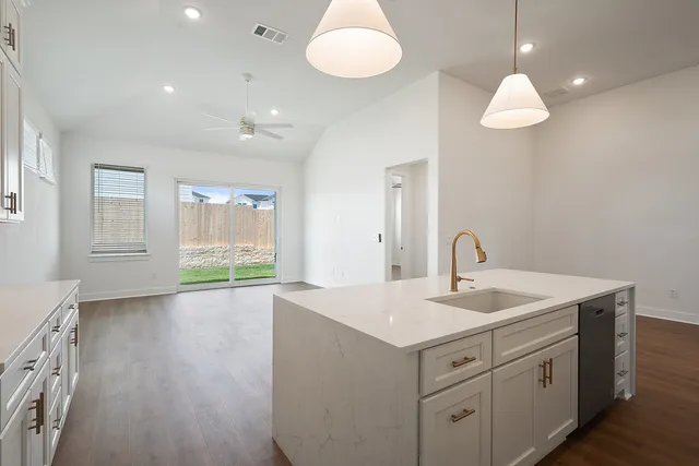 a view of kitchen with kitchen island granite countertop a sink and refrigerator