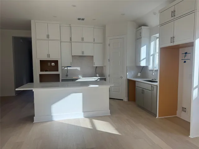 a kitchen with granite countertop white cabinets and stainless steel appliances