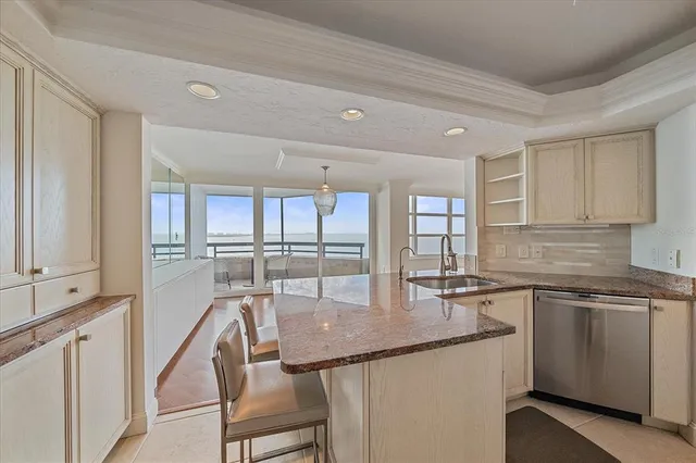 a kitchen with granite countertop a sink stainless steel appliances and cabinets