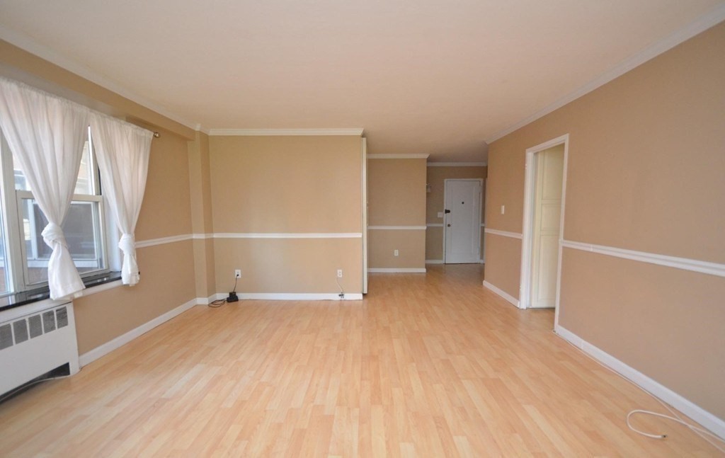 145 Pinckney Street, Unit 135 Boston, MA 02114 - Photo 3 of 7 a view of an empty room with wooden floor and a window