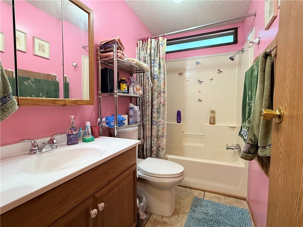 1637 Talc Road Bullhead City, AZ 86442 - Photo 27 of 37 Full bathroom with a textured ceiling, shower / bath combo, vanity, and light tile patterned floors