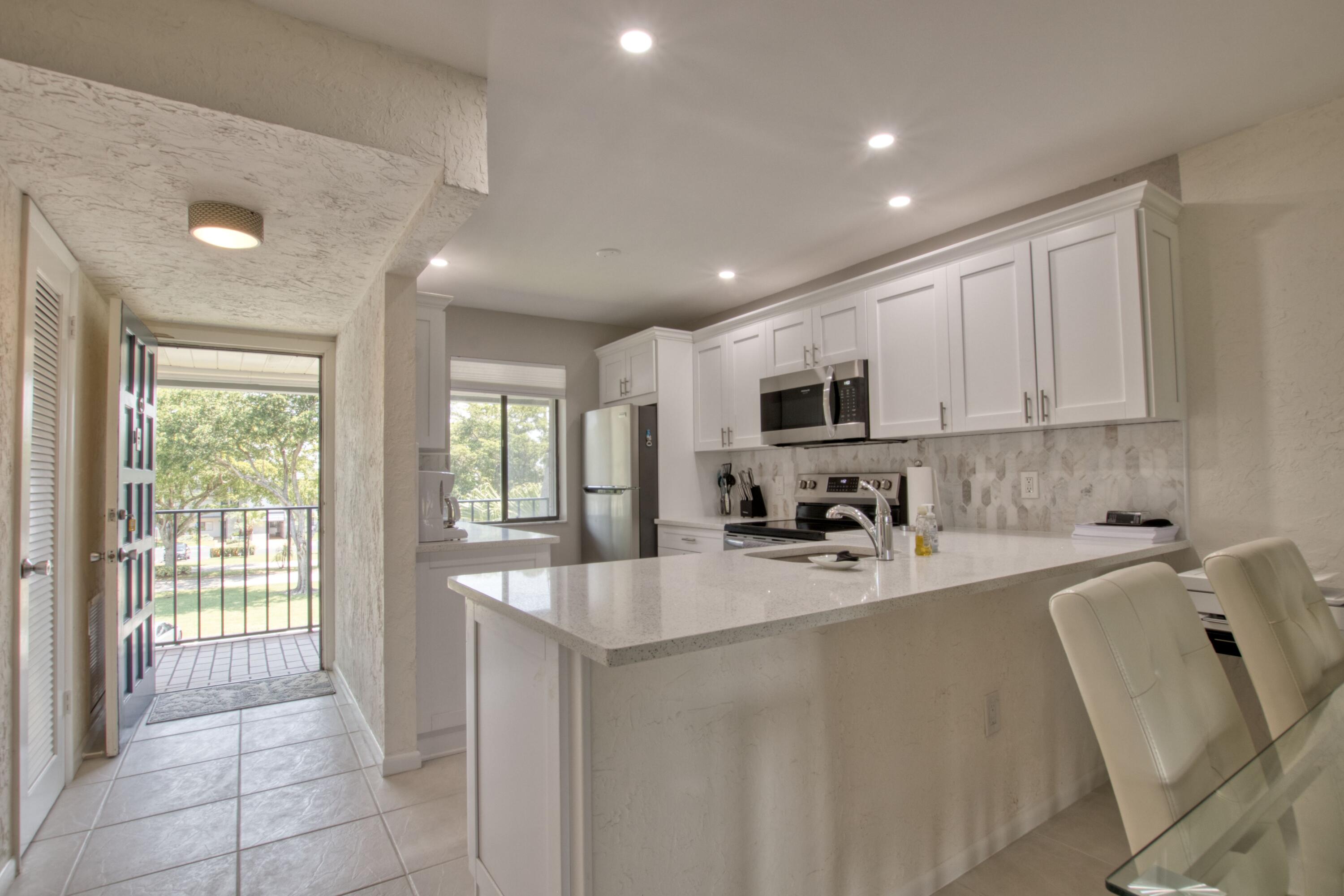 a kitchen with stainless steel appliances a sink a stove a microwave a sink a refrigerator and cabinets