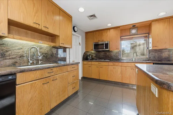 a kitchen with granite countertop a sink and white cabinets