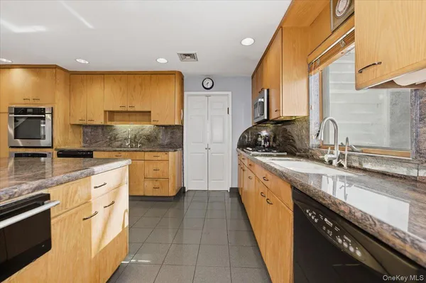 a kitchen with stainless steel appliances granite countertop a sink and cabinets