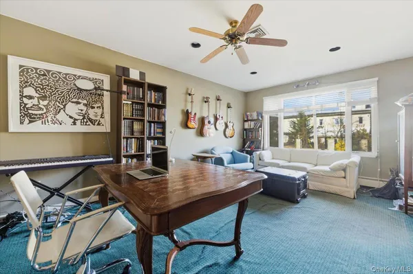 a view of a workspace with furniture and a large window