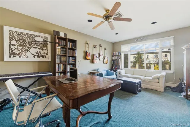 a view of a workspace with furniture and a large window