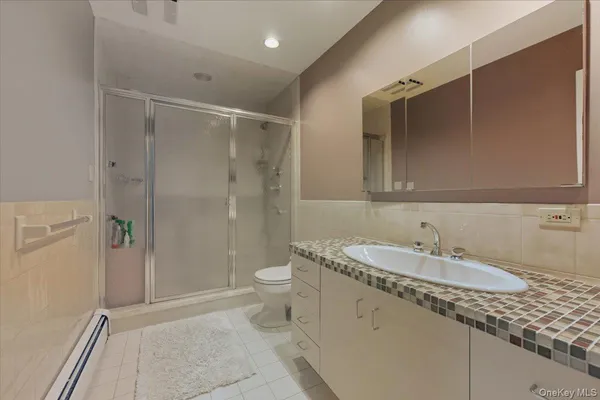 a bathroom with a sink a toilet and shower