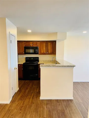 a kitchen with wooden cabinets a refrigerator and a stove