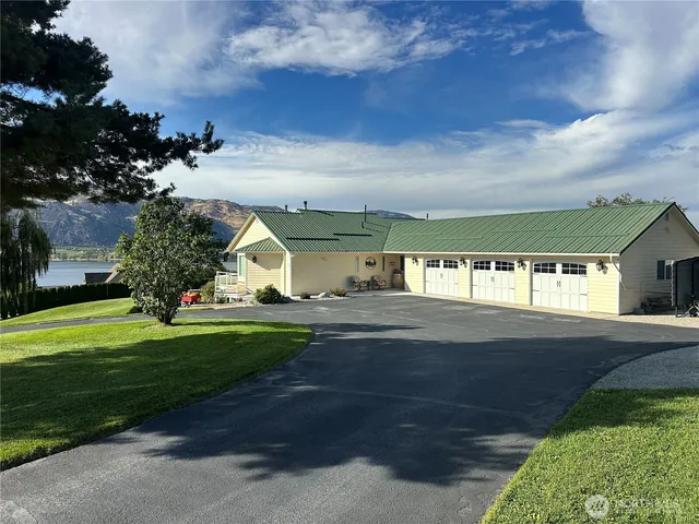 a view of a big house with a big yard and large trees