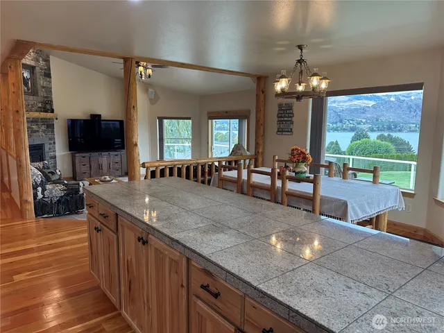 a large kitchen with granite countertop a large counter space and stainless steel appliances