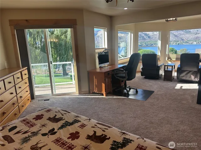 a view of a livingroom with workspace and a window