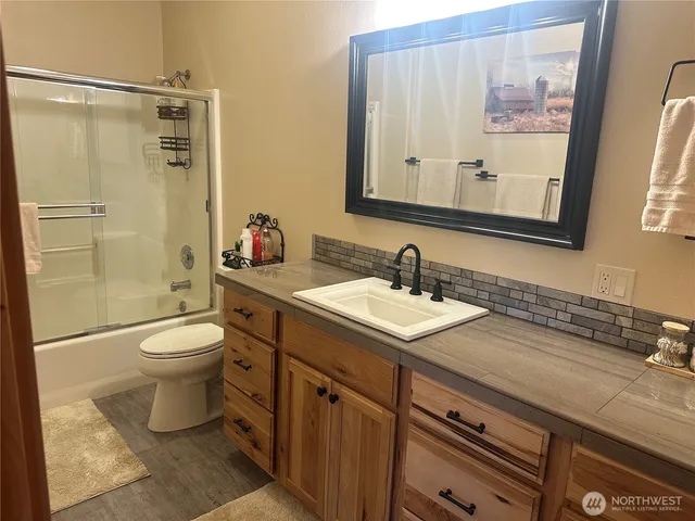 a bathroom with a granite countertop sink toilet and shower