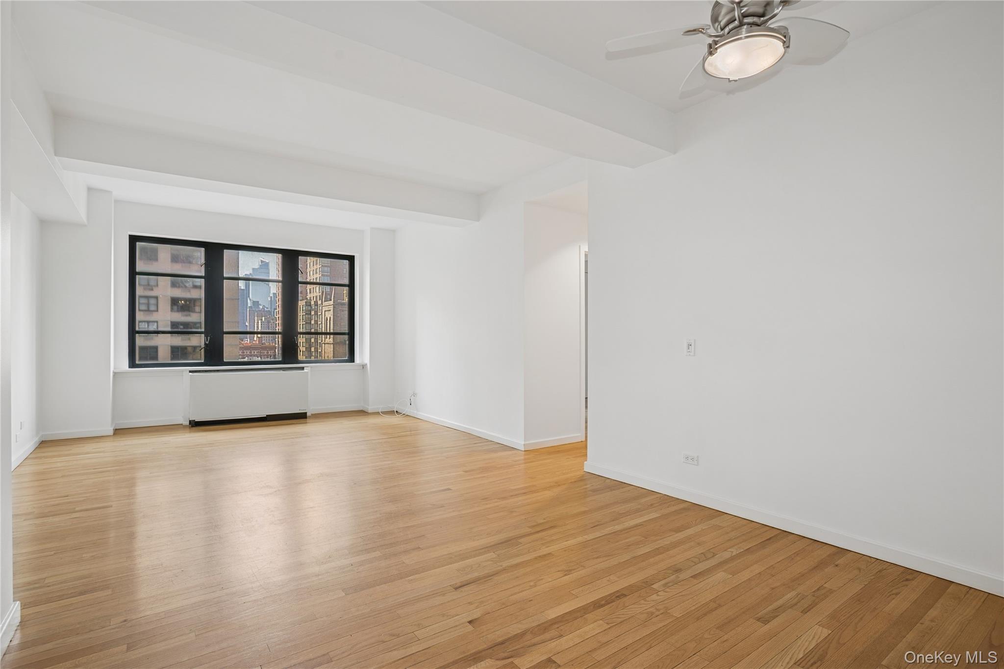 43 West 61st Street, Unit 12F Manhattan, NY 10023 - Photo 1 of 14 an empty room with wooden floor and windows