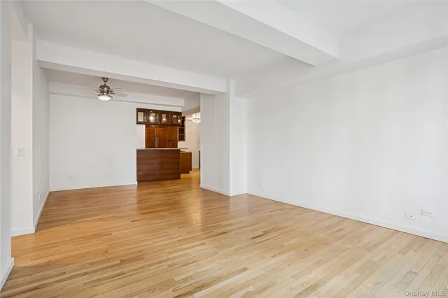a view of empty room with wooden floor and cabinet