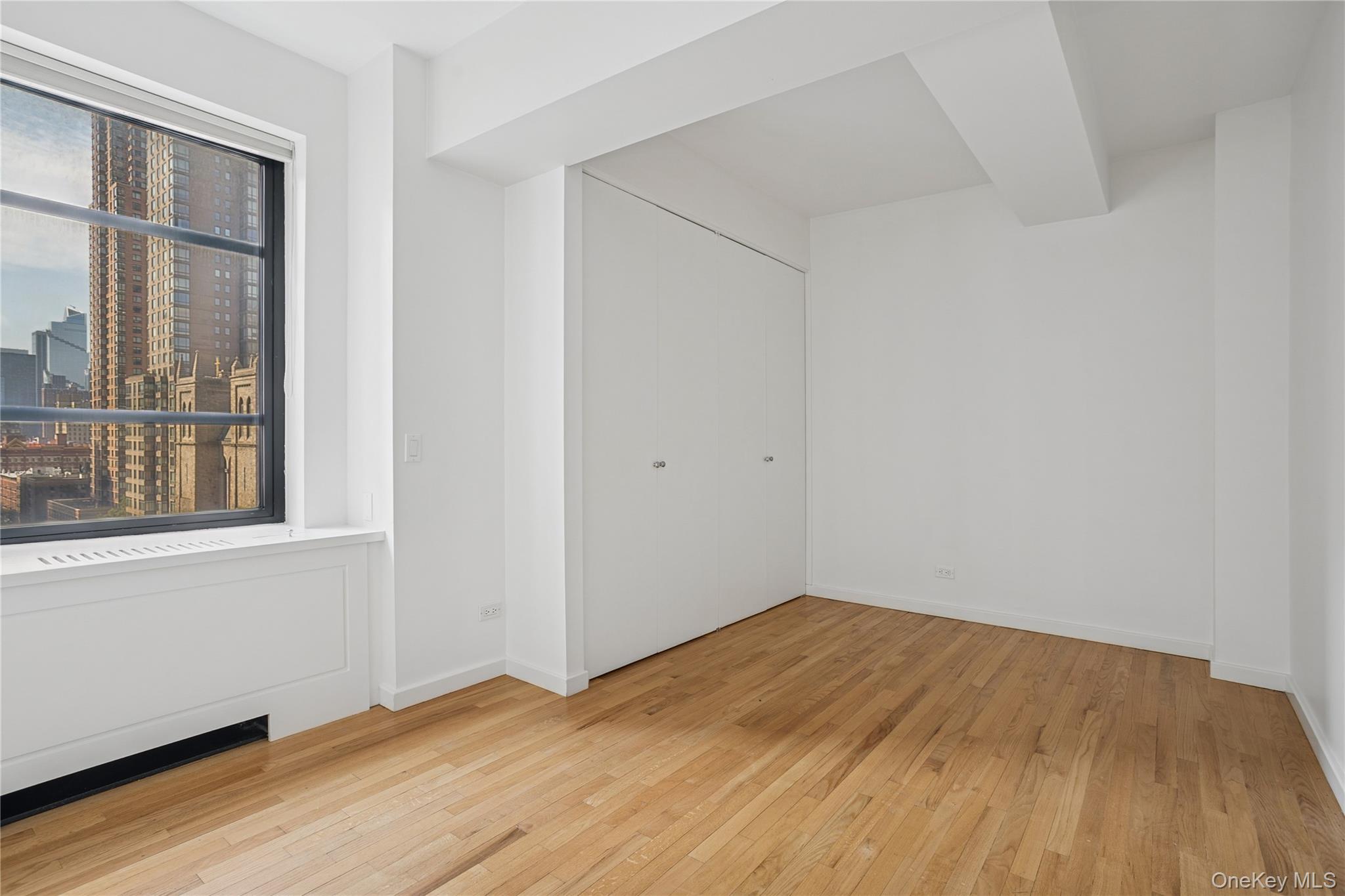 43 West 61st Street, Unit 12F Manhattan, NY 10023 - Photo 7 of 14 a view of empty room with wooden floor and fan