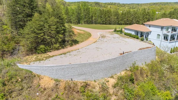 a view of a swimming pool with lawn chairs under an umbrella