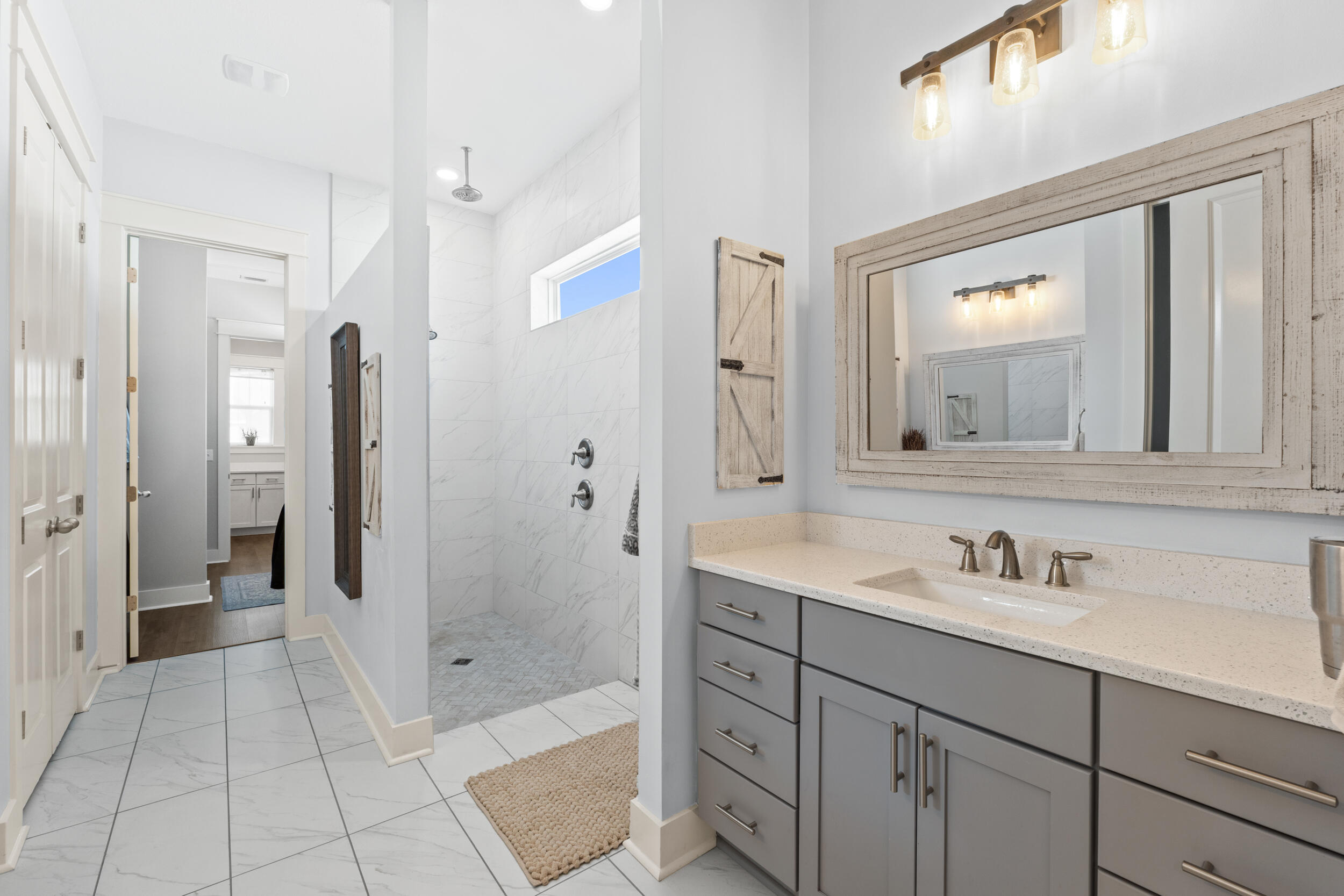 1313 North Discovery Loop Panama City, FL 32405 - Photo 15 of 50 a bathroom with a shower sink and mirror