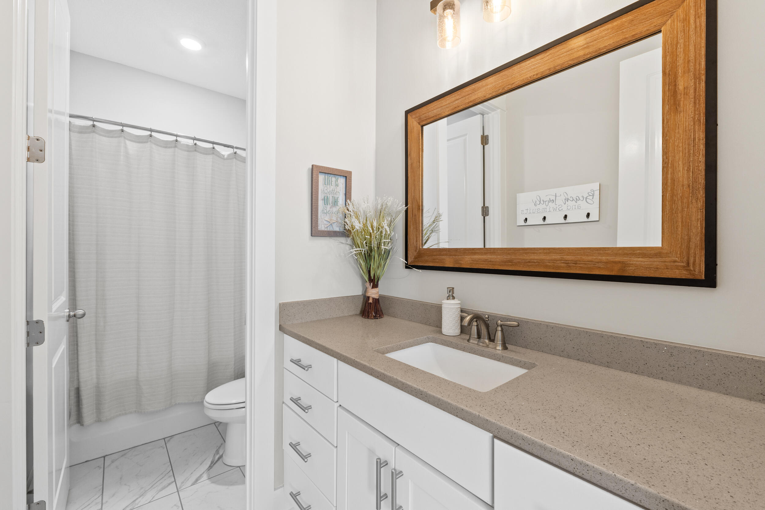 1313 North Discovery Loop Panama City, FL 32405 - Photo 35 of 50 a bathroom with a granite countertop sink mirror vanity and toilet