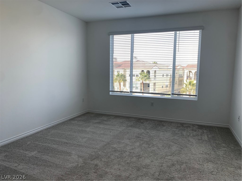 2555 Hampton Road, Unit 7109 Henderson, NV 89052 - Photo 17 of 34 A well-lit room with crown molding, offering views of the neighborhood through a wide window.
