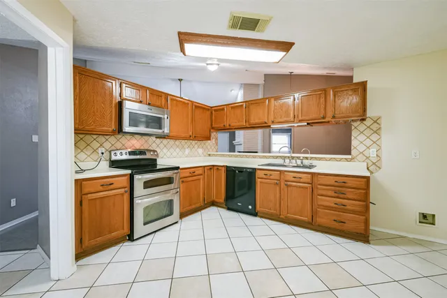 a kitchen with stainless steel appliances granite countertop a sink and cabinets