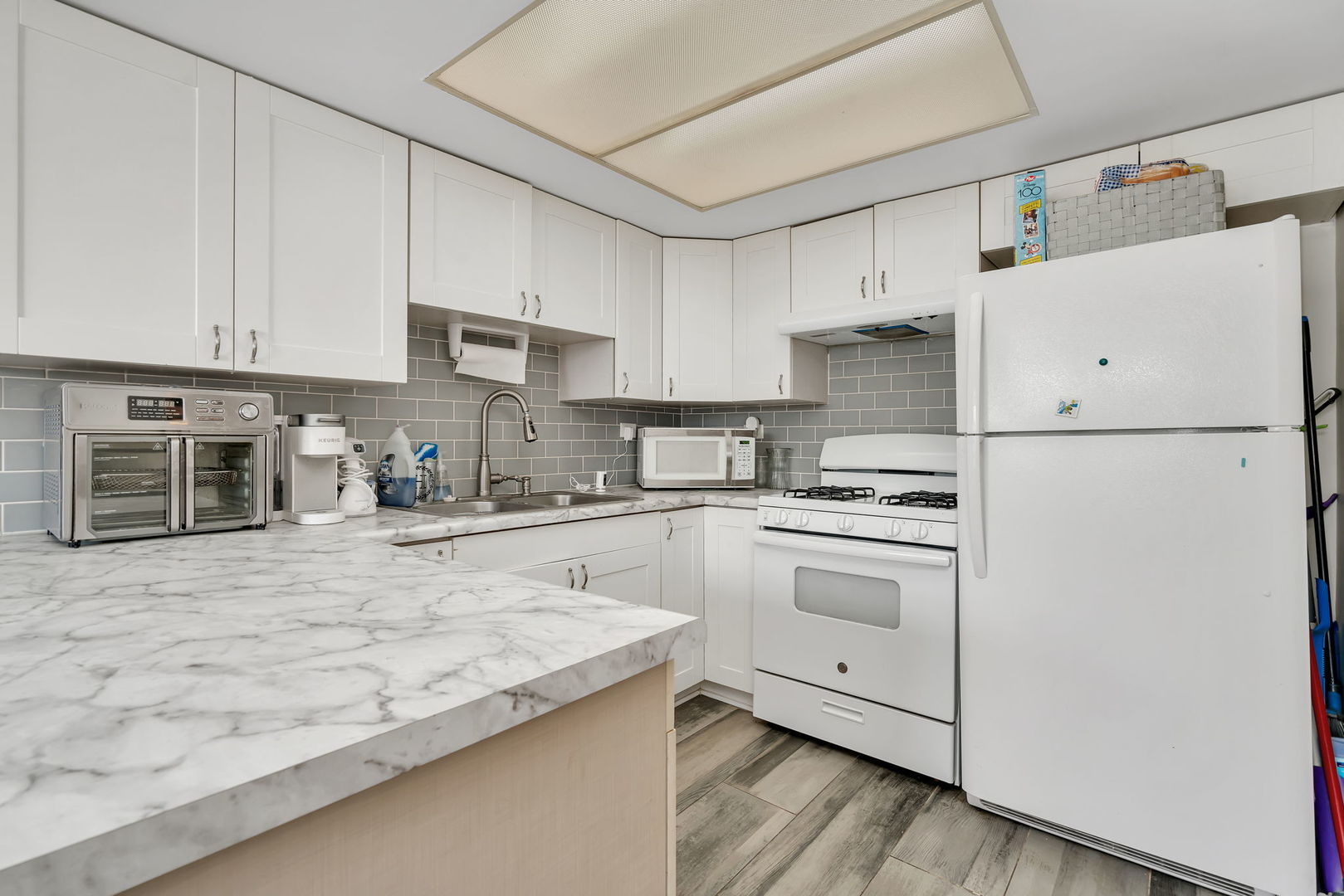 8010 West 84th Street Justice, IL 60458 - Photo 7 of 32 a kitchen with granite countertop white cabinets and white appliances