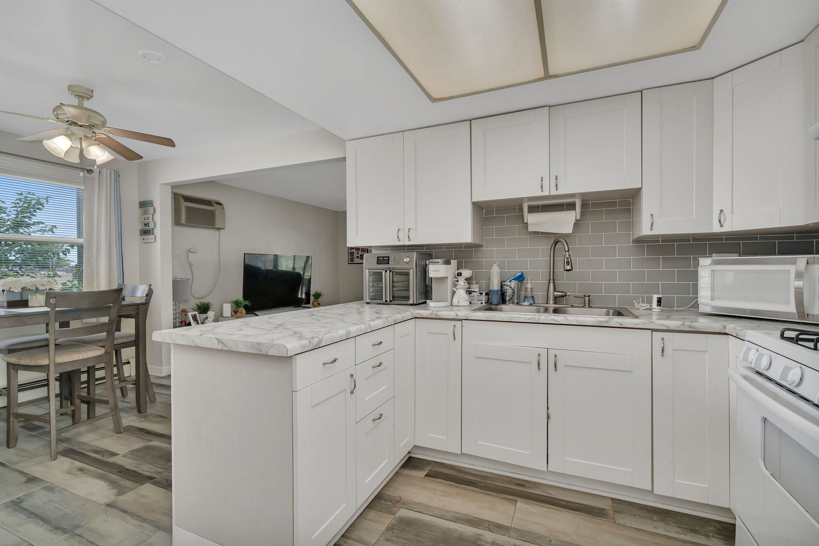 8010 West 84th Street Justice, IL 60458 - Photo 8 of 32 a kitchen with granite countertop white cabinets and white appliances