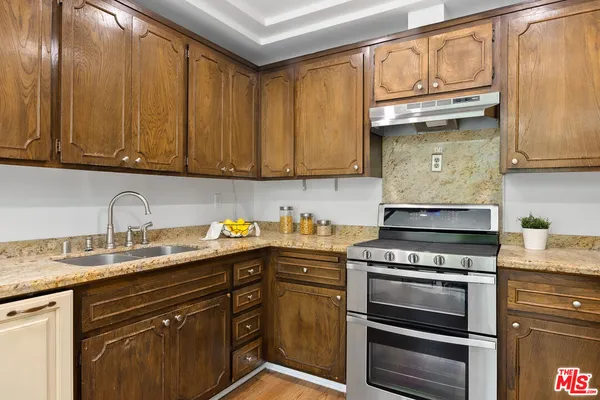 a kitchen with granite countertop cabinets stainless steel appliances and a sink
